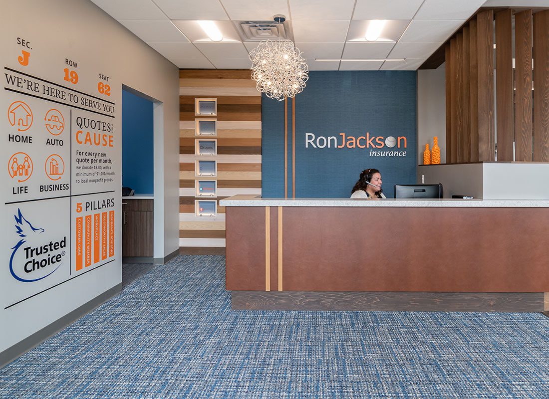 Contact - View of Front Reception Area Inside the Modern Themed Ron Jackson Insurance Office with a Smiling Receptionist Speaking to a Client While Looking at her Computer