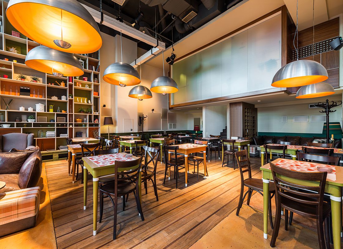 Insurance by Industry - Look Inside a Modern Interior of a Restaurant with Industrial Hanging Lights Over Tables and a Wooden Floor